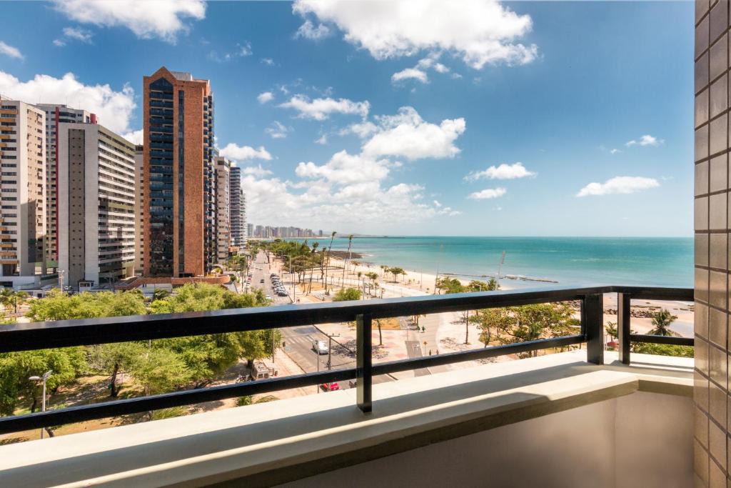 a balcony with a view of the beach and buildings at Particular Golden Beira Mar in Fortaleza