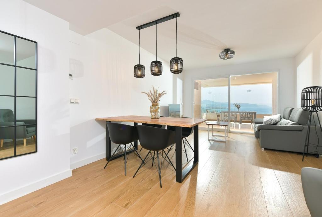 une salle à manger et un salon avec une table et des chaises dans l'établissement Apartamento de lujo de 2 dormitorios, à Torrox Costa