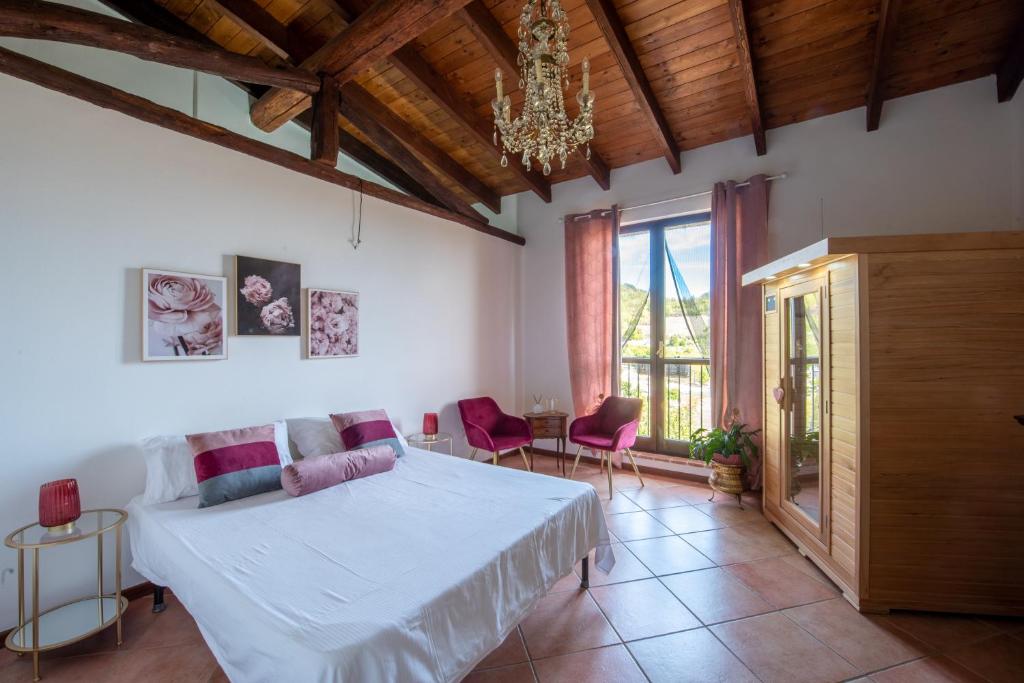 sypialnia z białym łóżkiem i żyrandolem w obiekcie Rosè House w mieście Camino