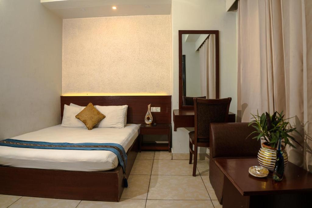 a hotel room with a bed and a desk and a mirror at Laguna Beach Hotel & Resort in Cox's Bazar