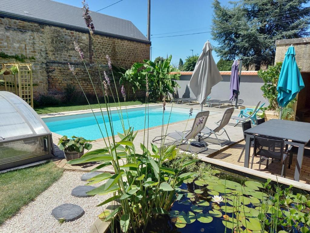 a backyard with a pool with a table and chairs and a picnic table and umbrella at Appartement, 2eme étage avec piscine partagée in Sedan