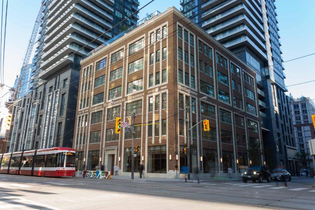 un grand bâtiment dans une rue de la ville avec un bus dans l'établissement Sutton Place Hotel Toronto, à Toronto