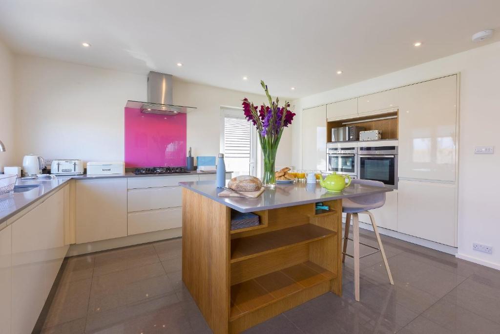 a kitchen with a vase of flowers on a counter at Secret Beach in Carbis Bay