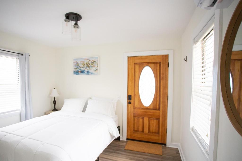 a bedroom with a bed and a wooden door at Cozy Studio - Blocks from the Ocean! in Jacksonville Beach