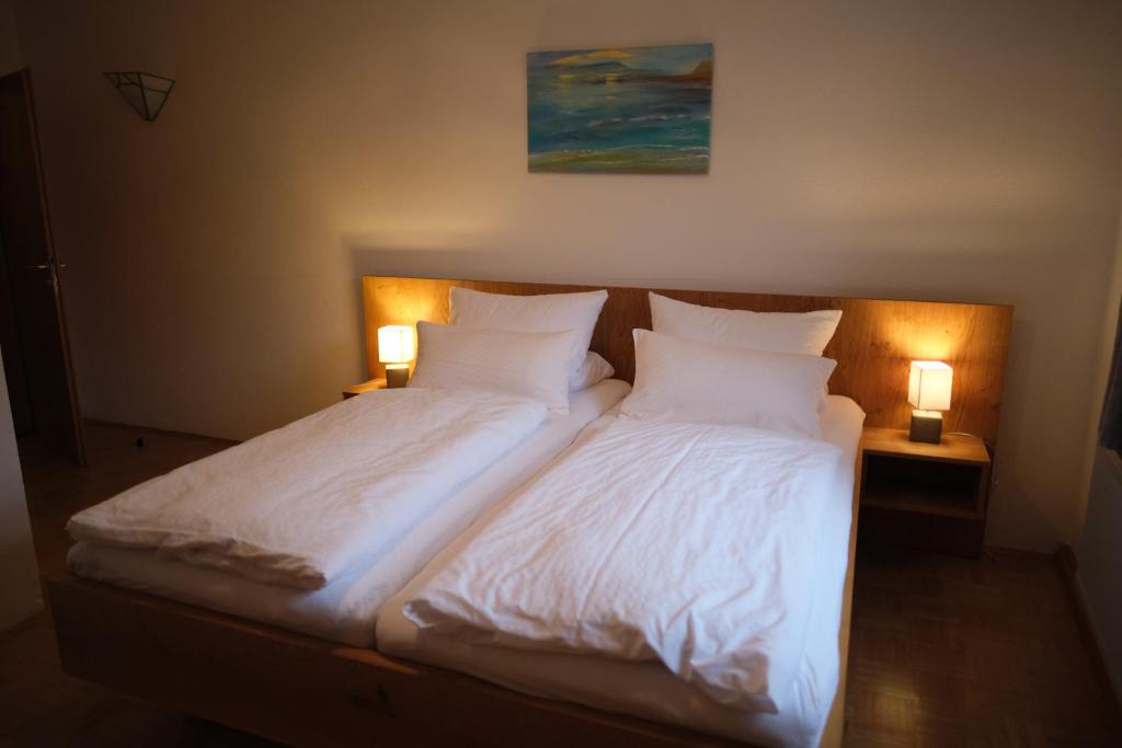 a bedroom with two beds with white sheets and two lamps at Wirtshaus Im Schloss Fürsteneck in Fürsteneck