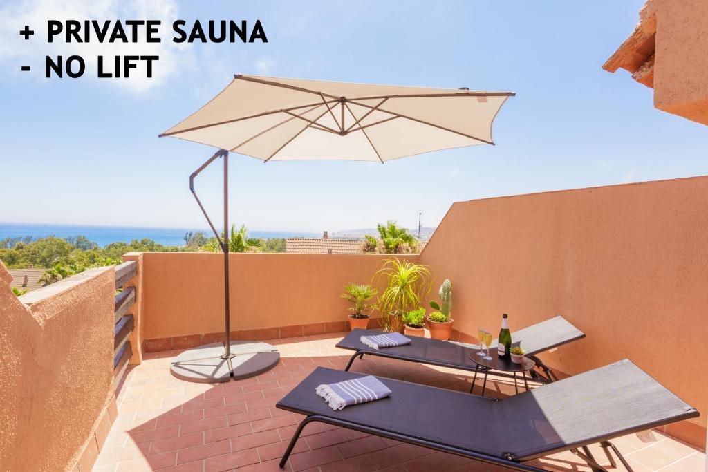 Fresh penthouse apartment with great sea views في كاساريس: فناء به طاولتين ومظلة