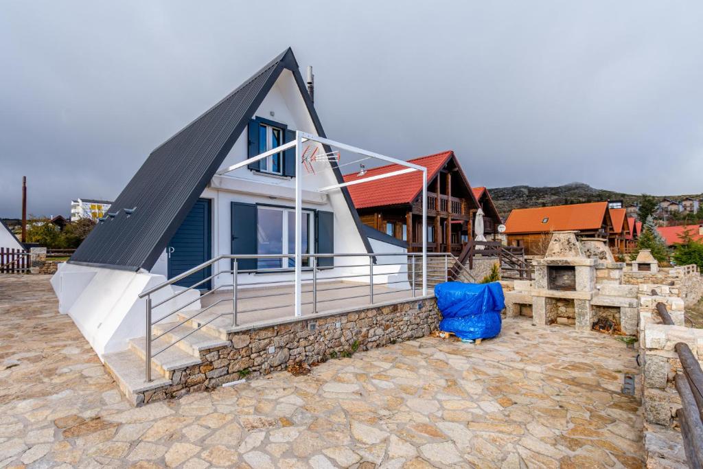 ein Haus mit einem blauen Stuhl davor in der Unterkunft Bungalow QJ in Covilhã