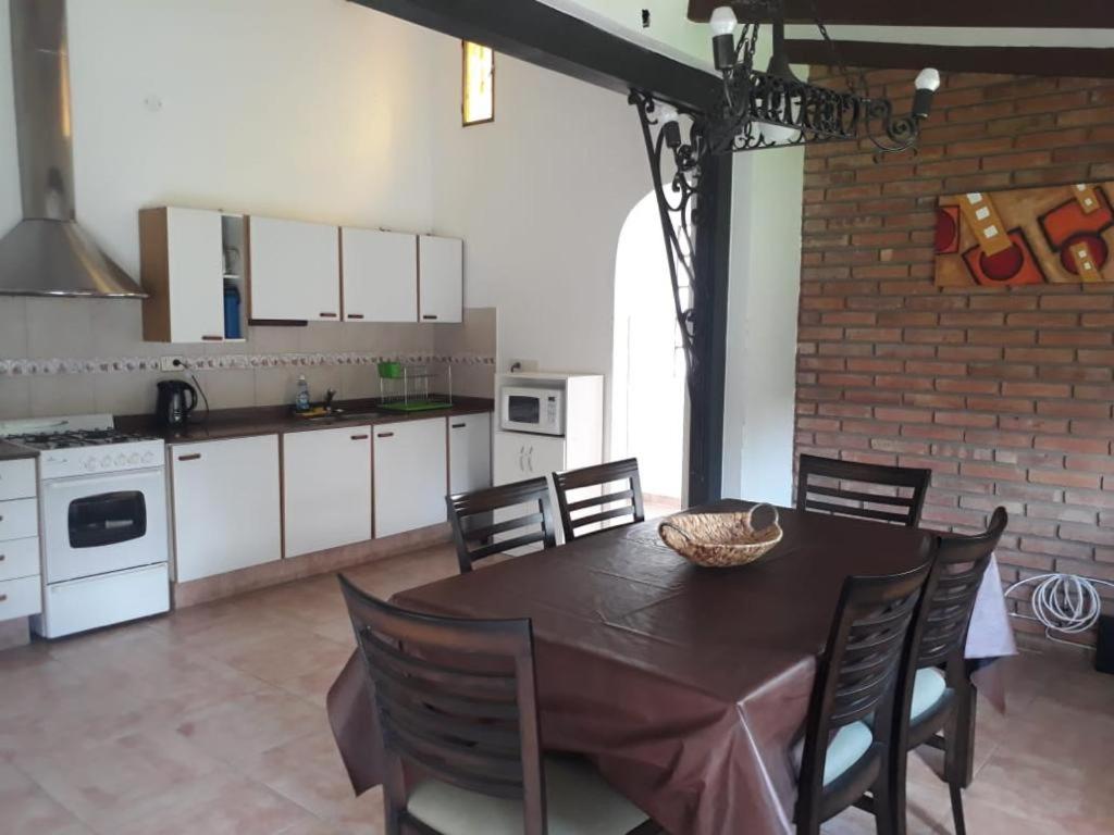 cocina y comedor con mesa y sillas en La casa del pino en Villa Carlos Paz