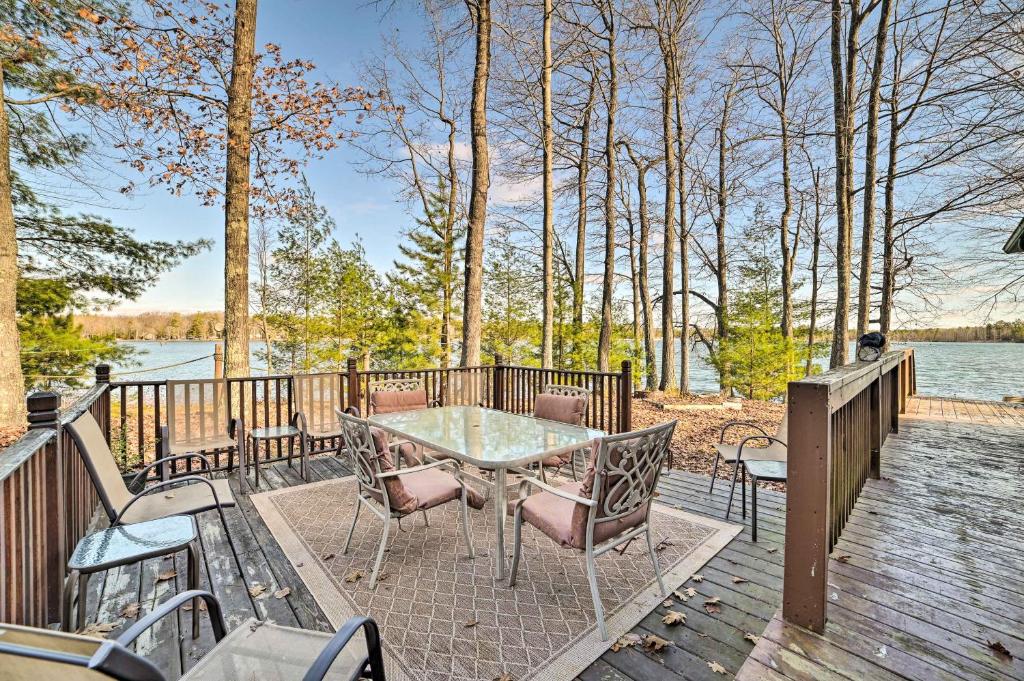 een tafel en stoelen op een terras met uitzicht op het water bij Secluded Lost Lake Cottage with Spacious Loft! in Hawks