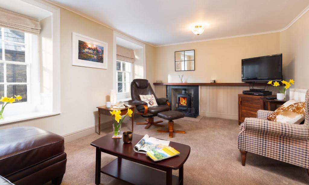 a living room with a couch chair and a fireplace at Ghyll Foot Cottage in Ambleside