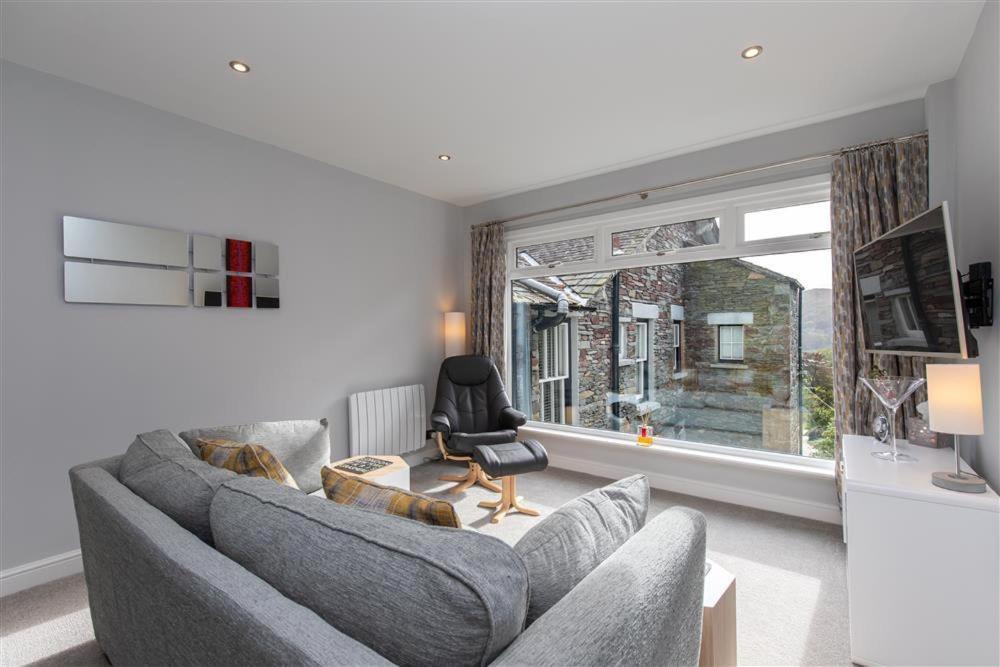 a living room with a couch and a chair and a window at Silver Howe in Grasmere