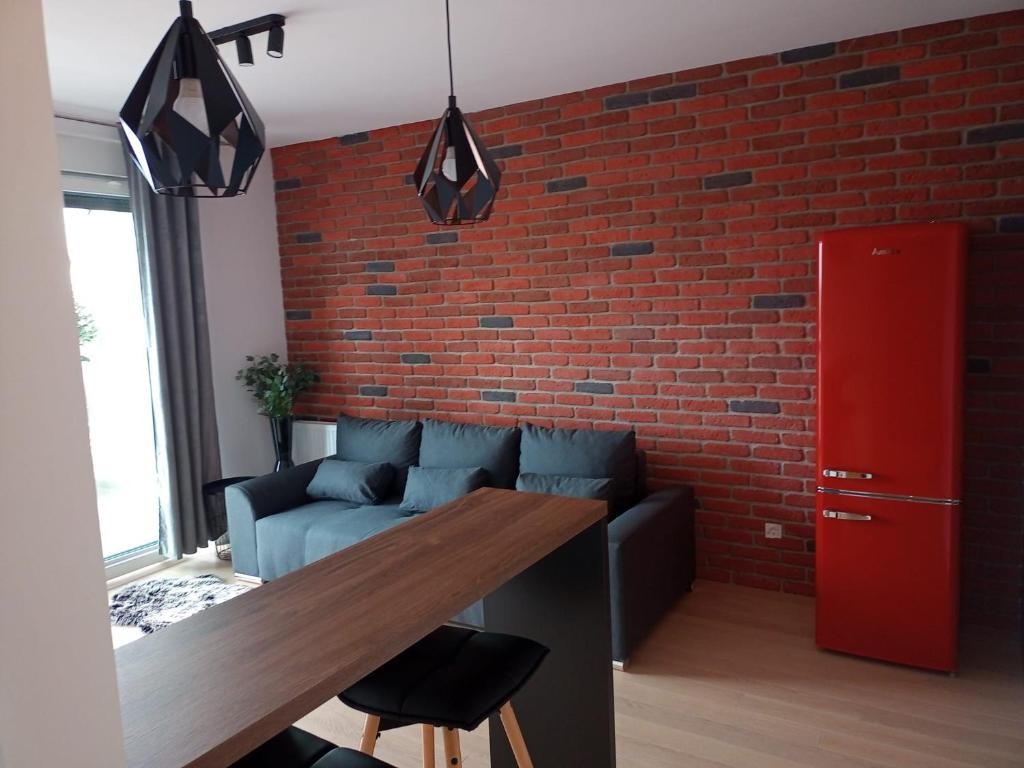 a living room with a brick wall and a wooden table at Arena ZG Apartment in Zagreb