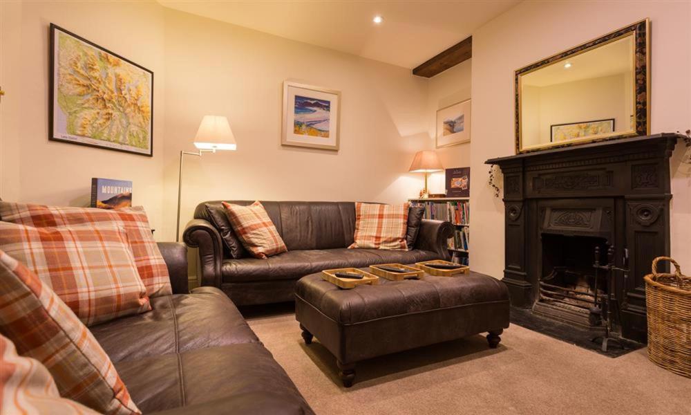 sala de estar con muebles de cuero y chimenea en Orrest Range, en Windermere