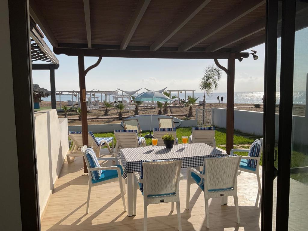 a table and chairs on a deck with a view of the beach at The Best Apartment on the beach 'Caesar Beach' Bogaz, North Cyprus in Boghaz