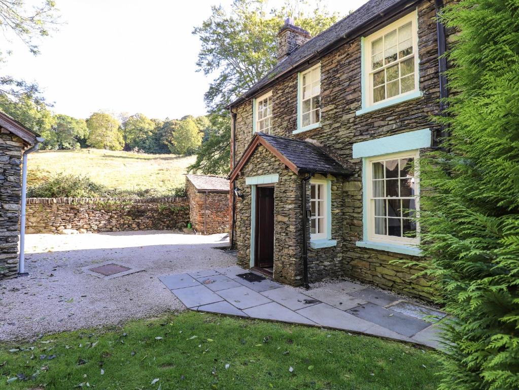 a brick house with a door and a driveway at Jessicas Cottage in Bowness-on-Windermere