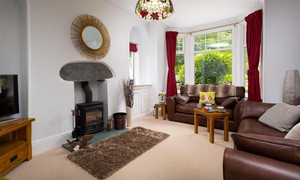 uma sala de estar com um sofá e uma lareira em Ellerthwaite House em Windermere