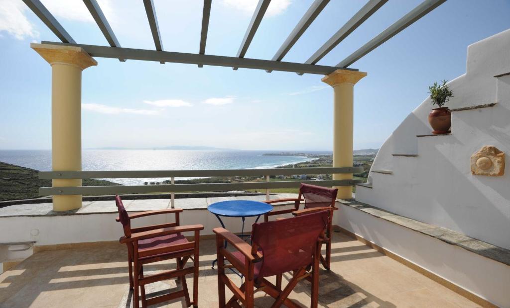 a table and chairs on a balcony with a view of the ocean at Tinos View Apartments in Tinos Town