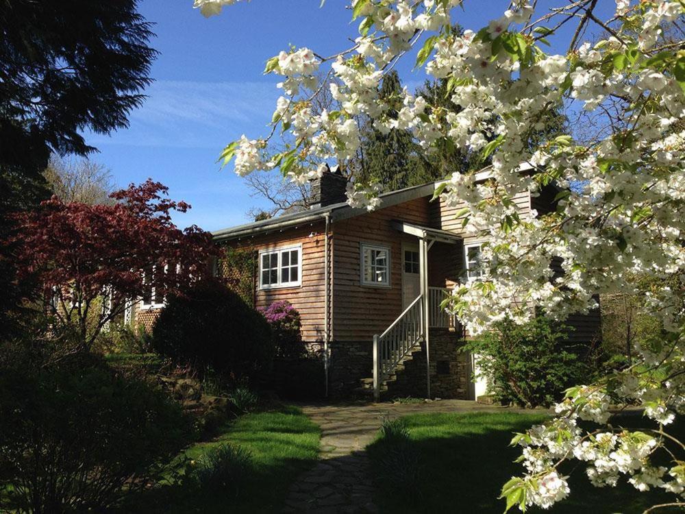 une maison avec un arbre planté de fleurs blanches dans l'établissement Rosewood by the River, à Ambleside