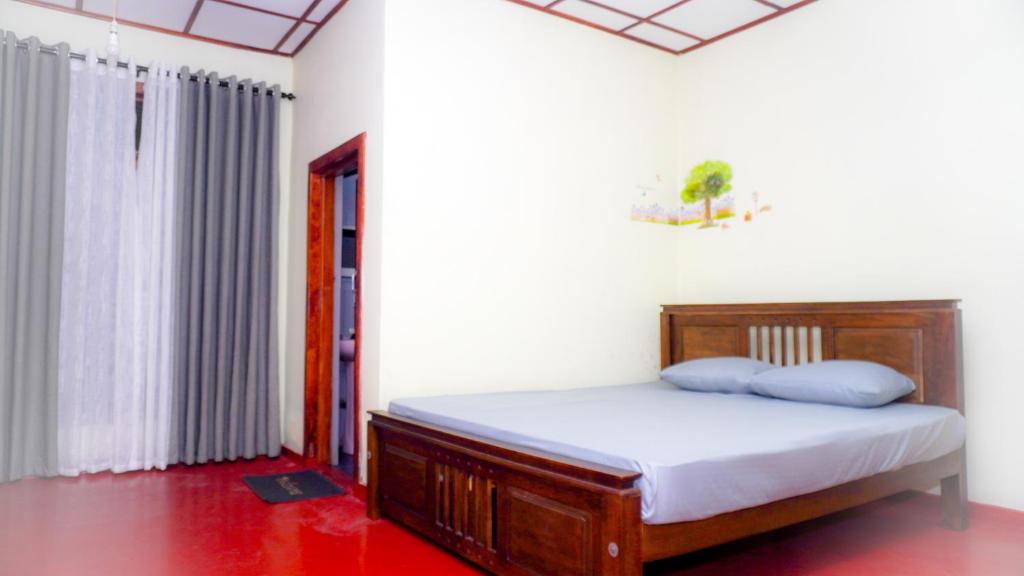 a bedroom with a bed with white sheets and blue pillows at V6 Holiday Bungalow in Badulla