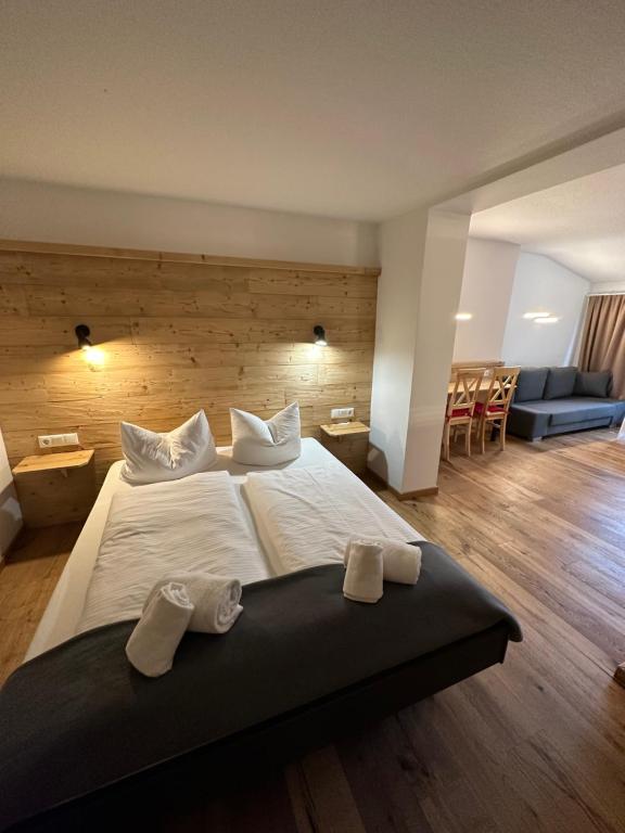 a bedroom with a large bed with two towels on it at Hotel Bergstätter Hof in Immenstadt im Allgäu