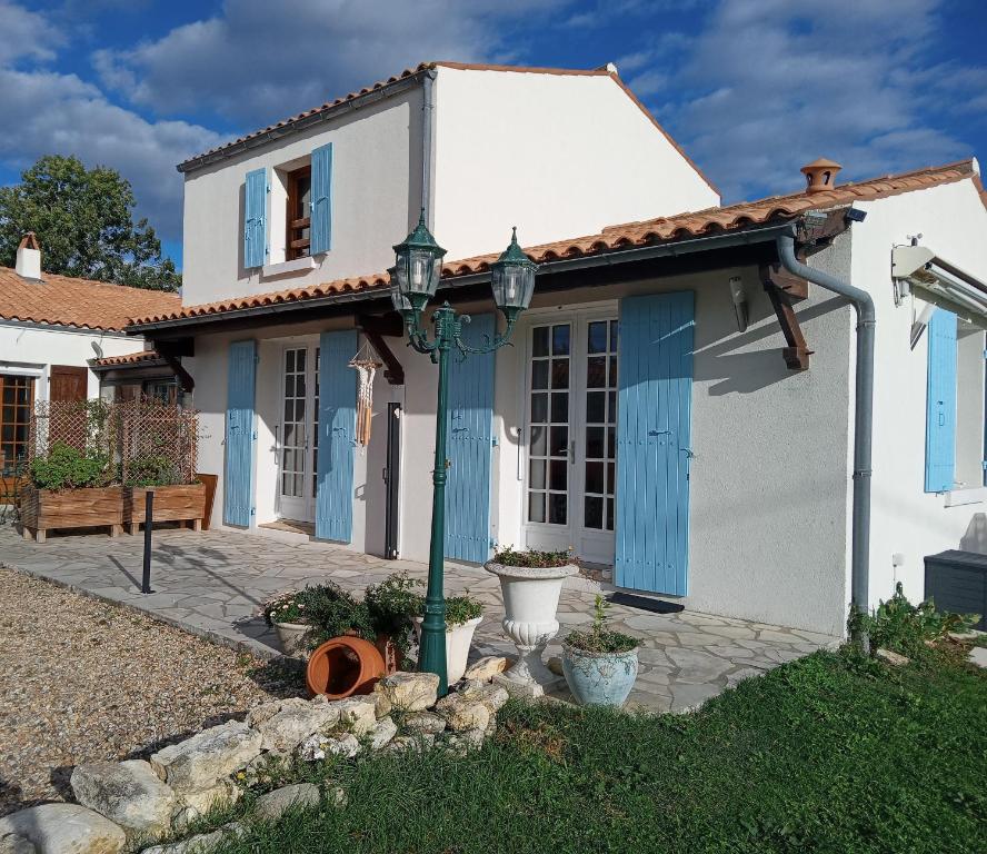 Una casa blanca con persianas azules. en Oléron côte ouest, 3 étoiles, en La Cotinière