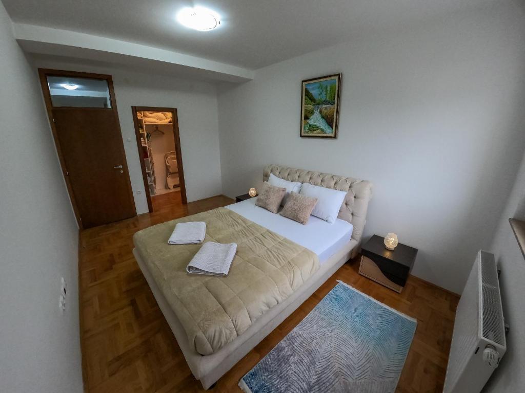a small bedroom with a bed with white sheets at Apartman City Center AN Trebinje in Trebinje