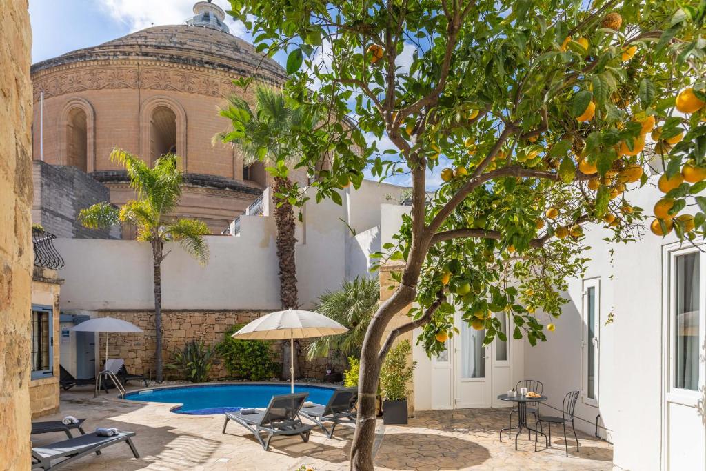 einen Innenhof mit einem Pool und einem Gebäude in der Unterkunft Mosta Dome B&B in Mosta