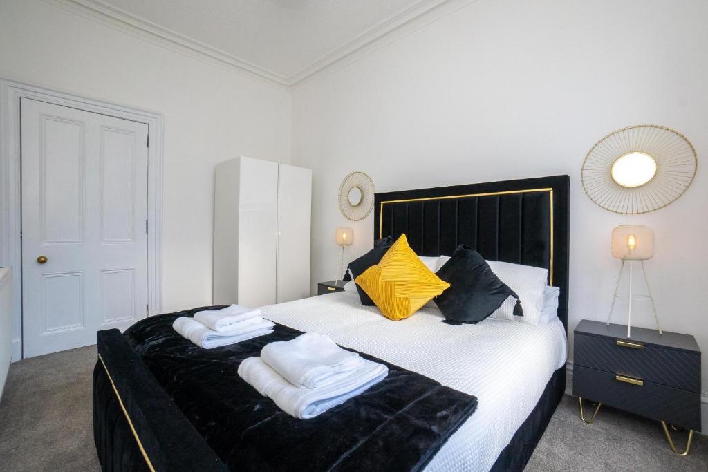 a bedroom with a large bed with towels on it at Brulee House - Luxury 2 Bed Apartment in Aberdeen Centre in Aberdeen