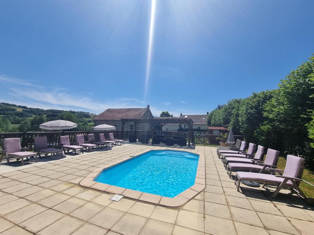 - une piscine avec chaises longues et chaises sur la terrasse dans l'établissement Meadow View Gîtes - Grande gîtes, piscine, wi-fi - Janaillat, Creuse, France, 23250, à Janaillat