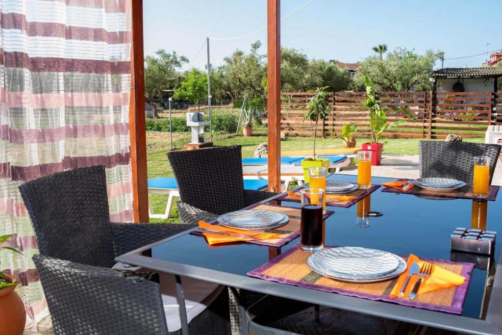 een tafel en stoelen op de patio van een huis bij Konstantinos holidays house in Laganas