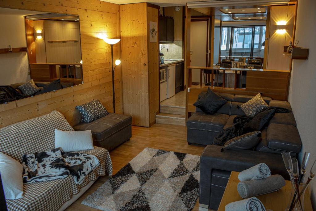 un salon avec deux canapés et une cuisine dans l'établissement Studio confort, Front de neige, Parking gratuit, à Isola 2000