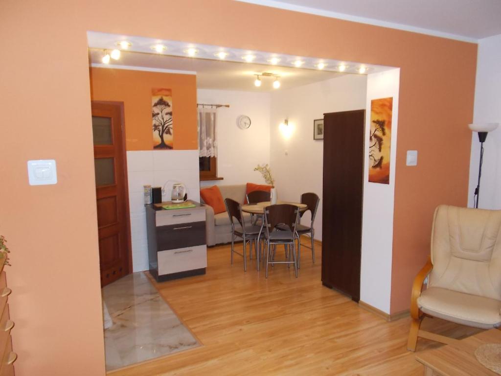 a living room with a table and chairs and a kitchen at Apartament cynamonowy in Grudziądz