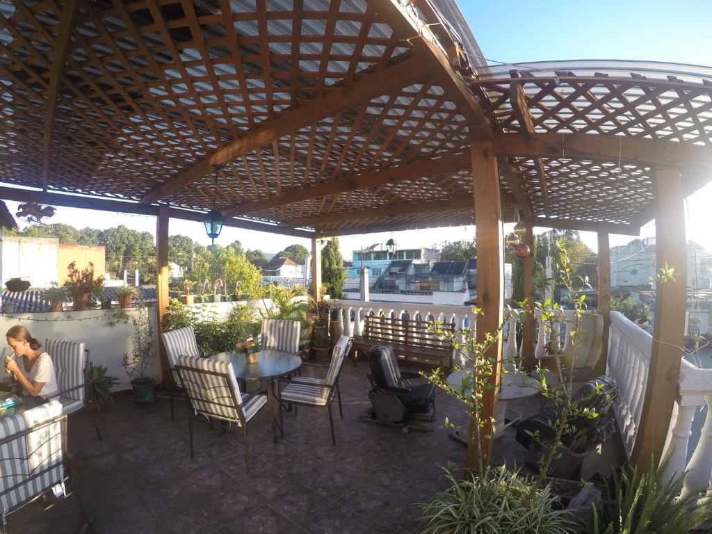 uma pérgola de madeira com uma mesa e cadeiras num pátio em Mariana's Petit Hotel em Guatemala