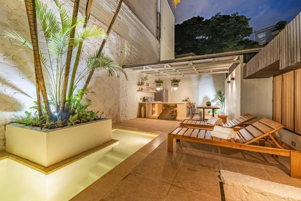 - un salon avec bancs et plantes dans un bâtiment dans l'établissement Provenza 6 Bedroom House by HOUSY HOST, à Medellín