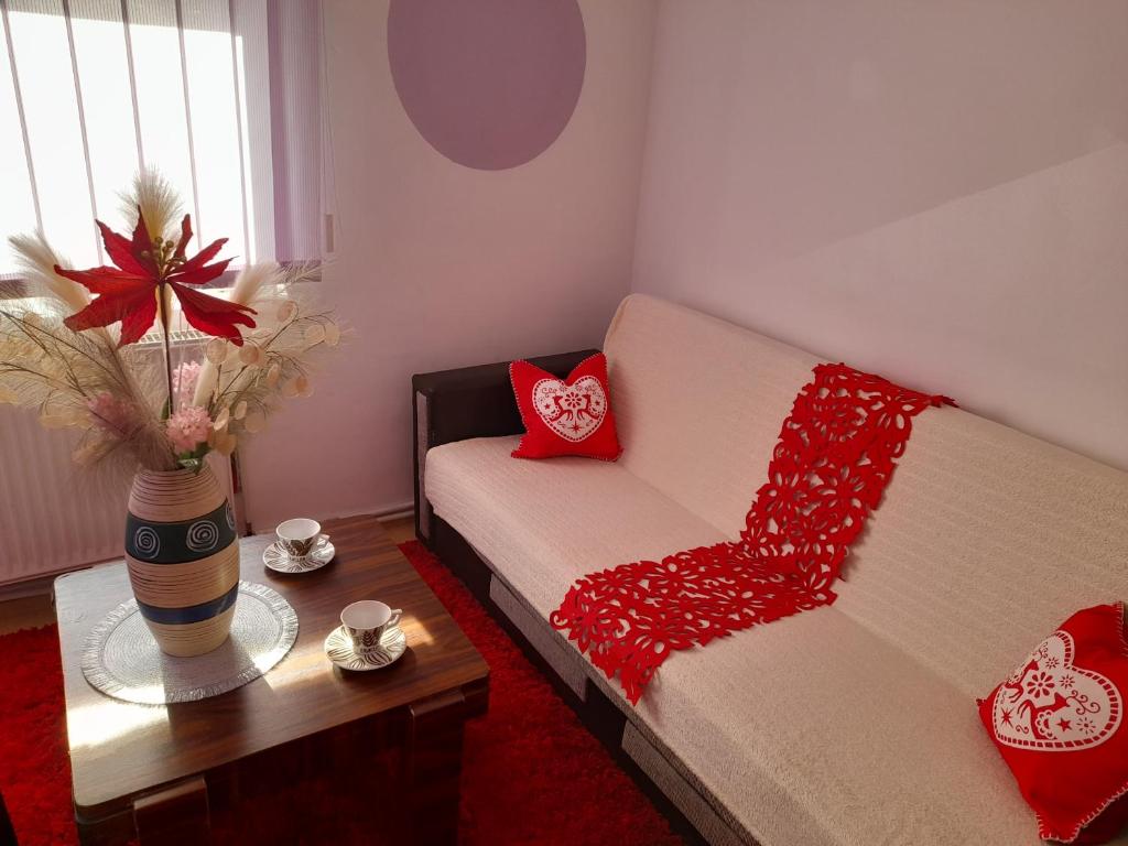 een woonkamer met een bank met rode kussens en een tafel bij Apartment boulevard Cetate in Alba Iulia