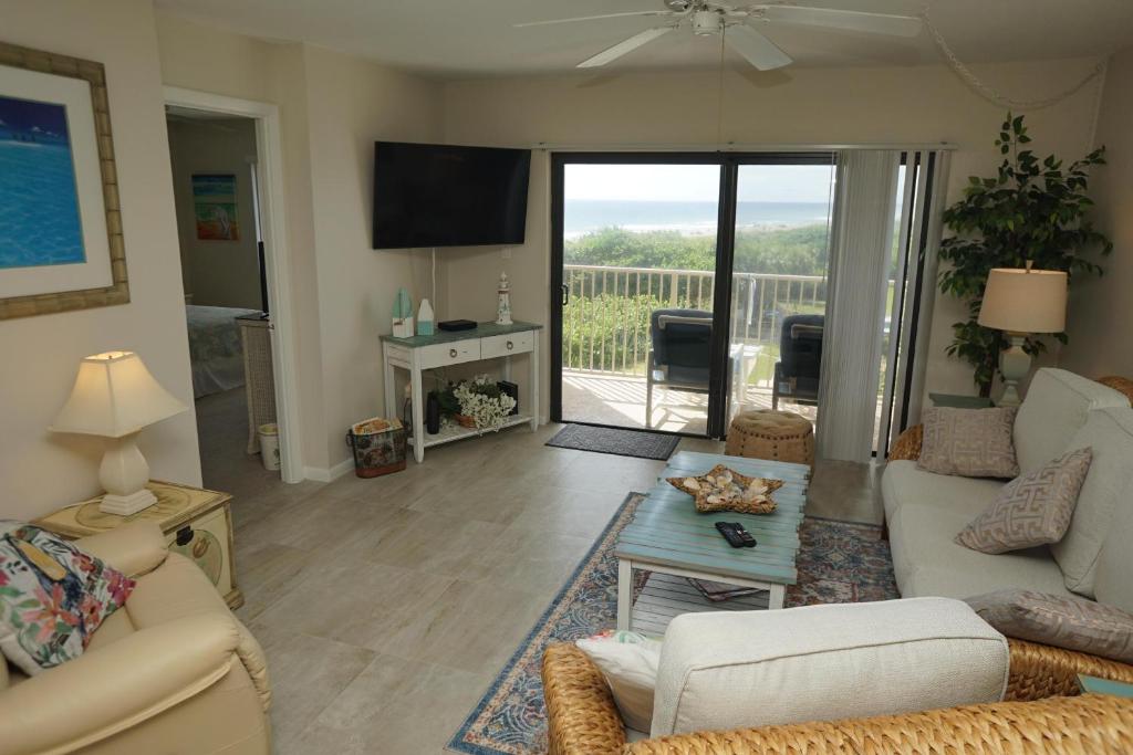 a living room with a couch and a table at Canaveral Towers Oceanfront 402! in Cape Canaveral