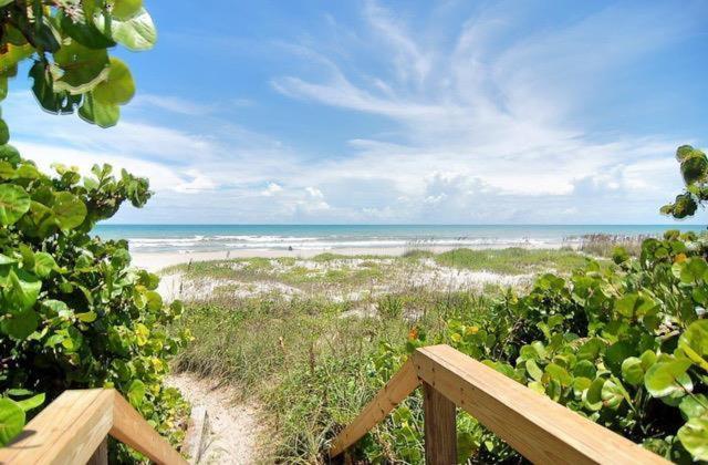 a view of a beach with the ocean in the background at Quiet Vista Del Mar 2 Bedroom Condo Beachfront Property in Cocoa Beach