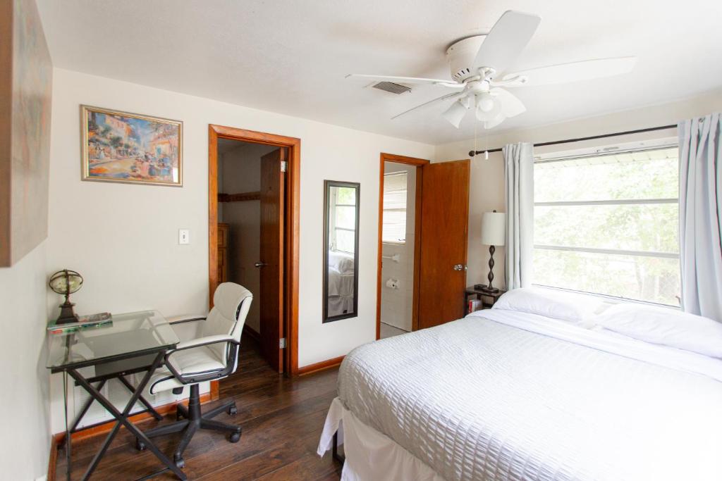 1 dormitorio con cama, escritorio y ventana en Cozy 1 Bedroom Unit - 4 Blocks from Jax Beach Pier! en Jacksonville Beach