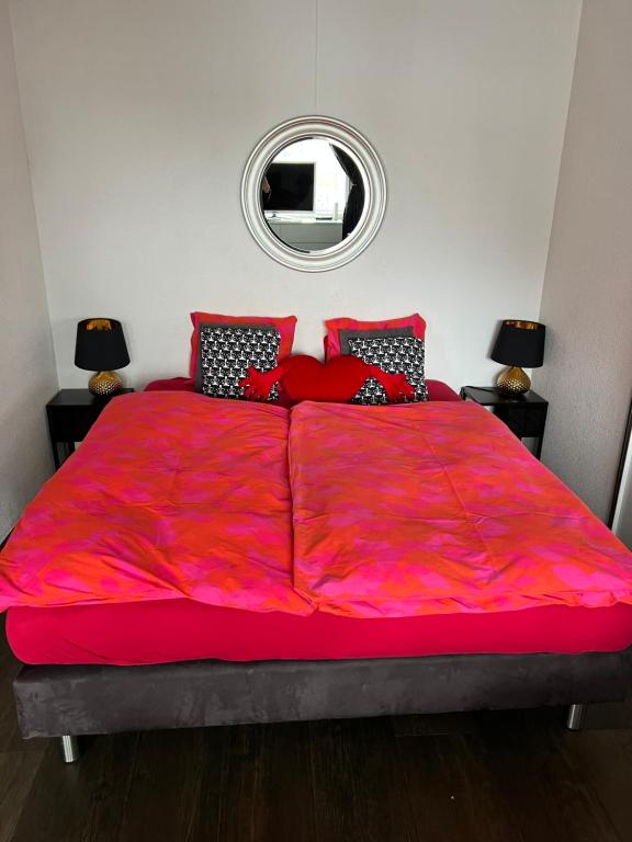 een groot bed met een rood dekbed in een slaapkamer bij Studio in Zürich