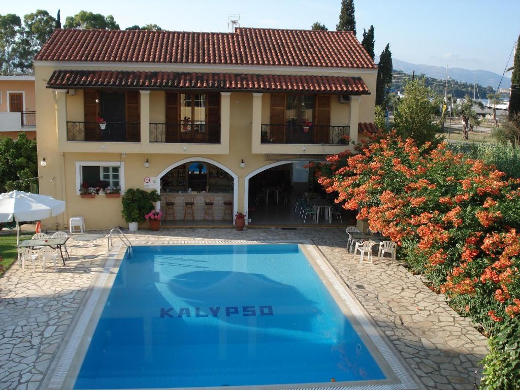 a villa with a swimming pool in front of a house at Kalypso Gouvia in Gouvia