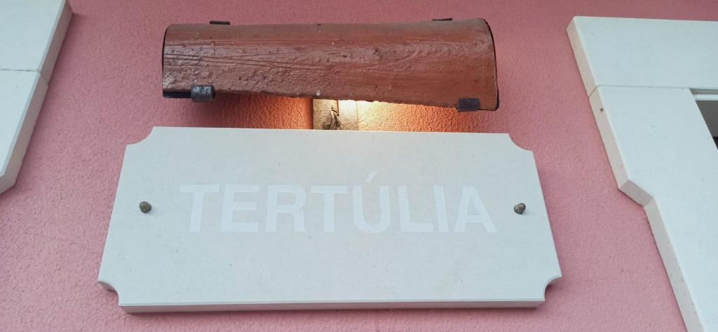 a sign on the side of a pink building at Casa Tertúlia in Covão do Coelho