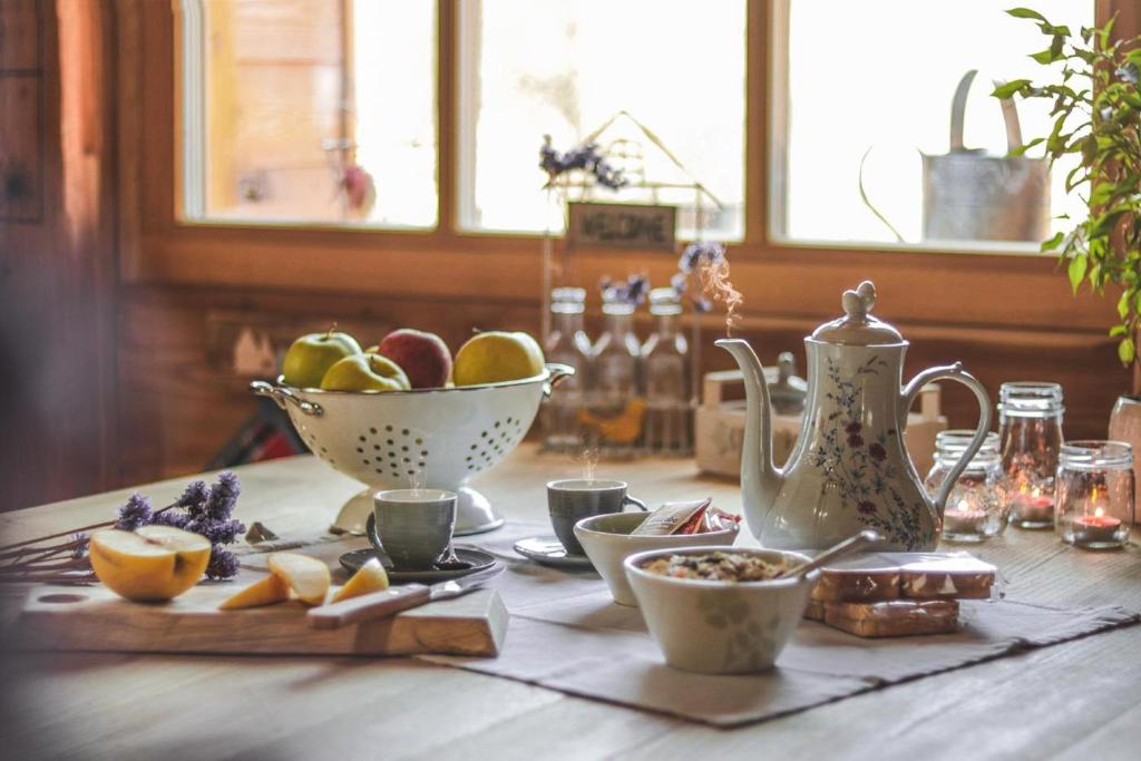 Frassilongo的住宿－Chalet Baita Incantata，一张桌子,上面放着一碗水果和茶壶