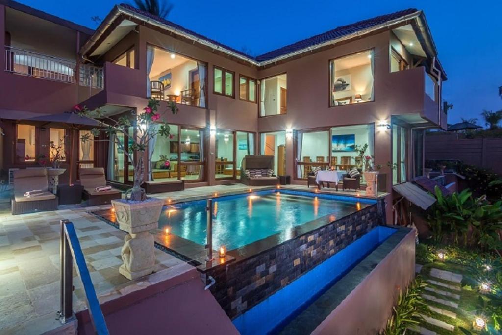 a house with a swimming pool in front of it at Villa Giuliana in Senggigi 