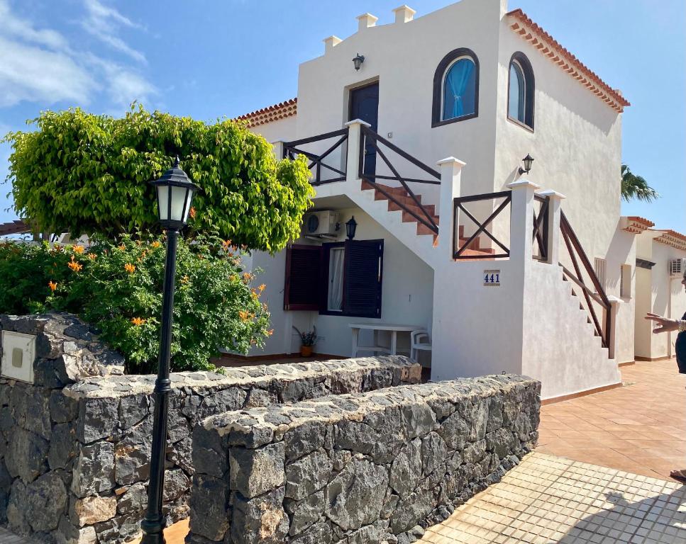 una casa con una pared de piedra y una luz de la calle en Juangy’s Apartments in Las Adelfas Golf del Sur en San Miguel de Abona