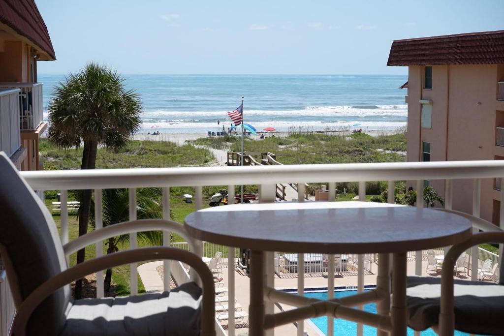 a balcony with a table and a view of the beach at WOW! Updated Oceanfront, Pool Front Spanish Main Condo 45! in Cocoa Beach