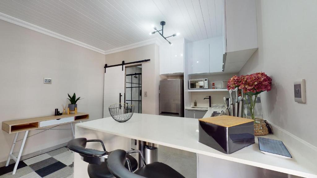 uma cozinha com um balcão branco e cadeiras em Seas the day Scottburgh by Top Destinations Rentals em Scottburgh