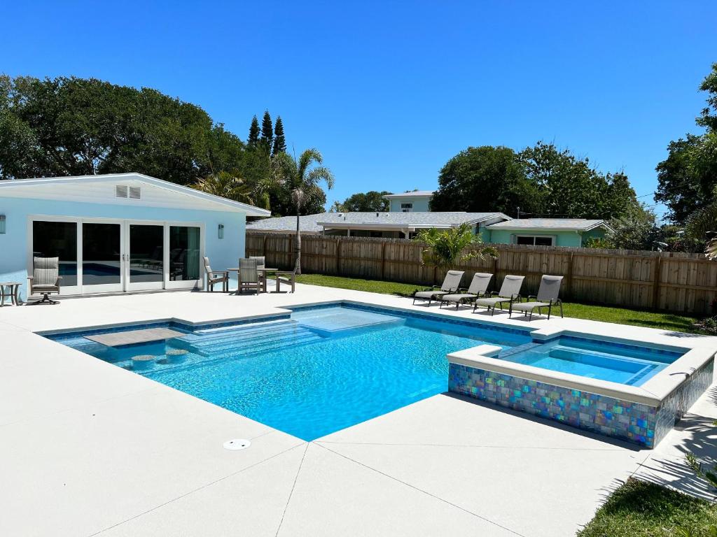 a swimming pool in a backyard with chairs around it at 213 Grant Ave in Cocoa Beach