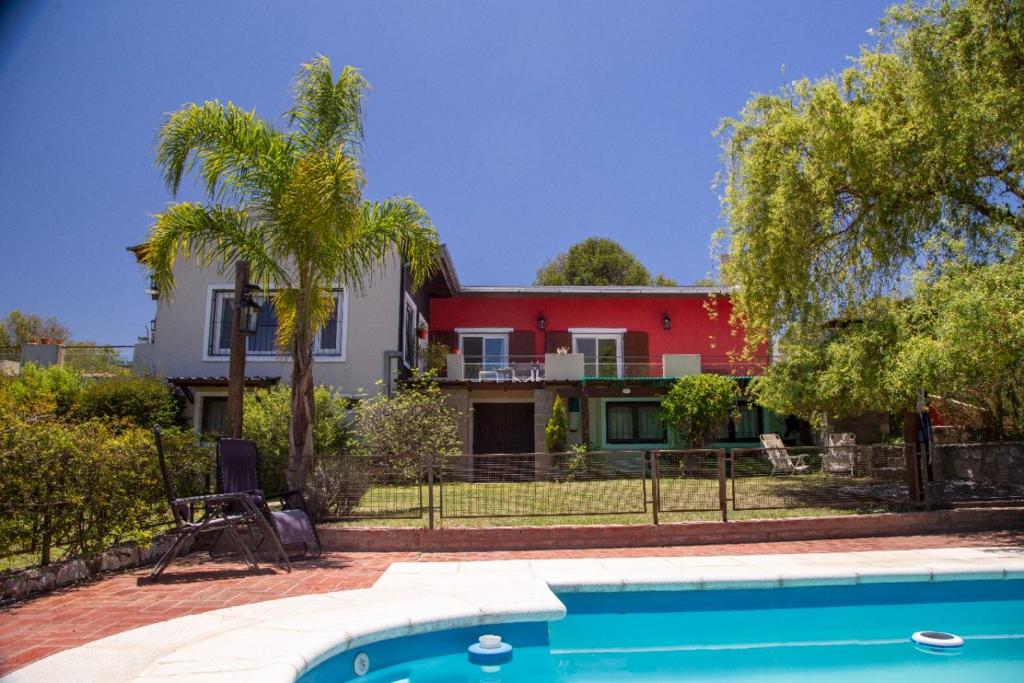 una casa con piscina frente a una casa en Chalet Maru en La Falda