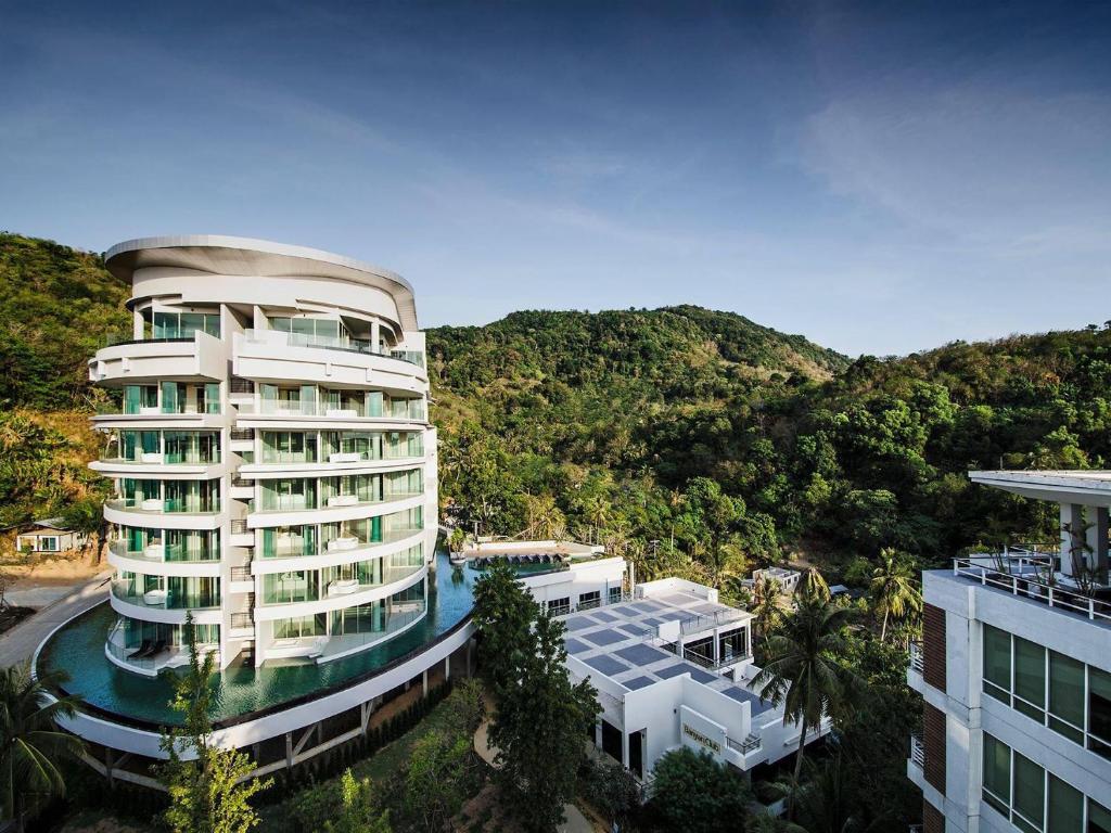 a building with a pool in front of a mountain at The Ark at Veloche Group by Lofty in Karon Beach
