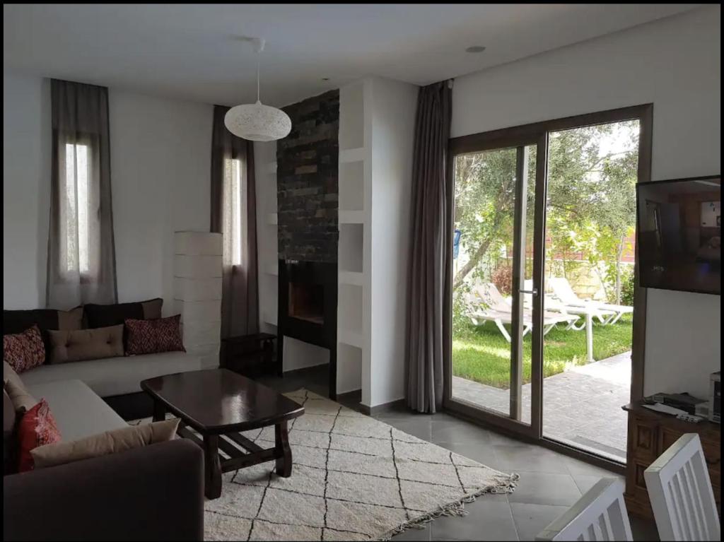 ein Wohnzimmer mit einem Sofa und einem Tisch in der Unterkunft Villa Toufitri in Agadir